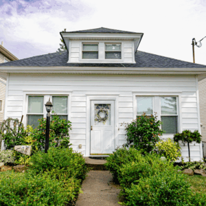 Symmetrical White Siding with Hipped Roof and Central Overhang